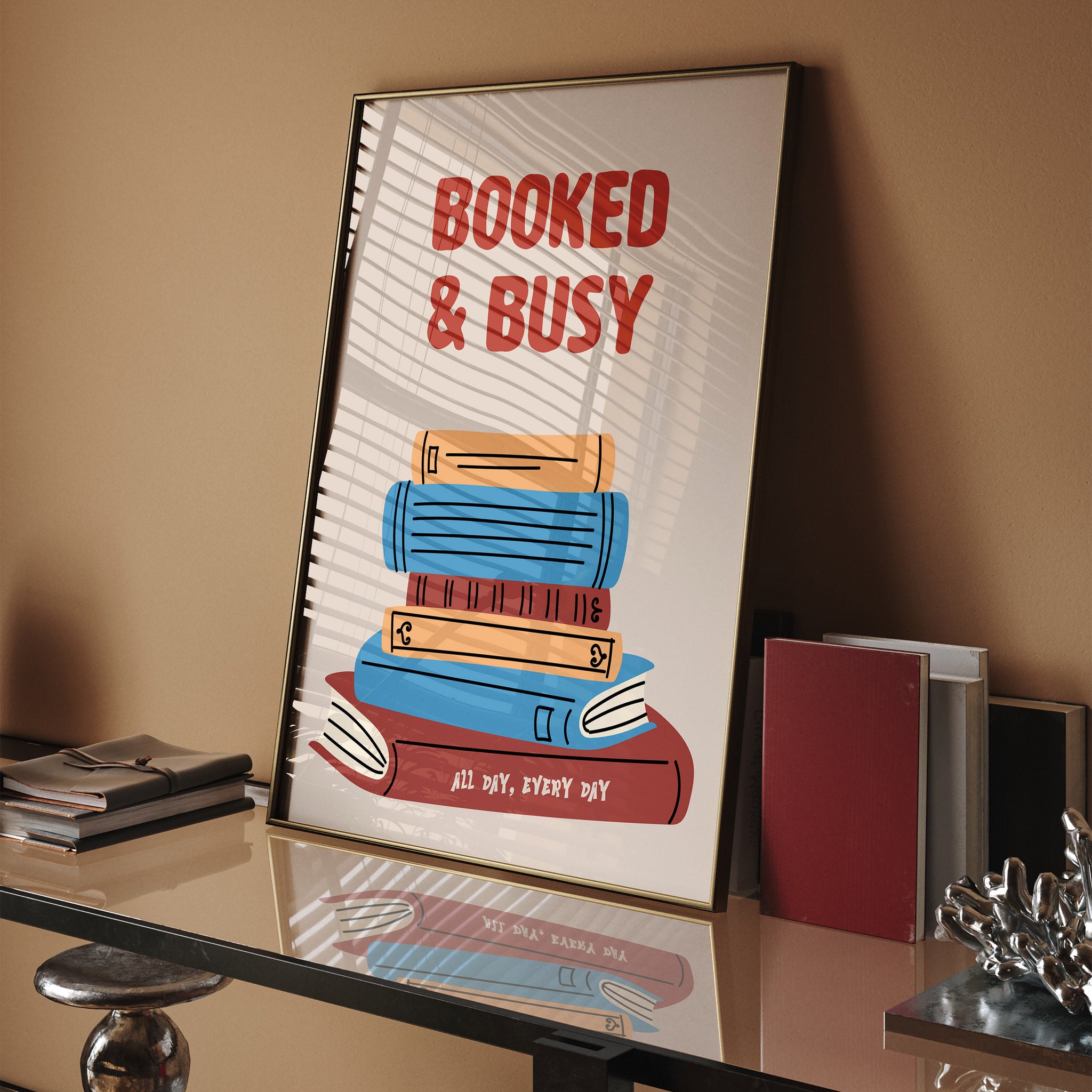 Wall art featuring "Booked & Busy" text with colorful book stack illustration
